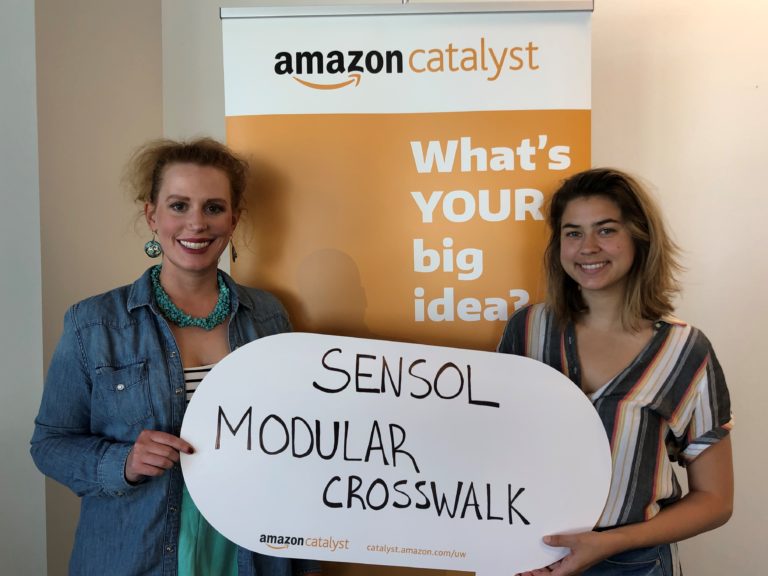 Janie Bube and Emma Petersen pose with Sensol Modular Crosswalk sign