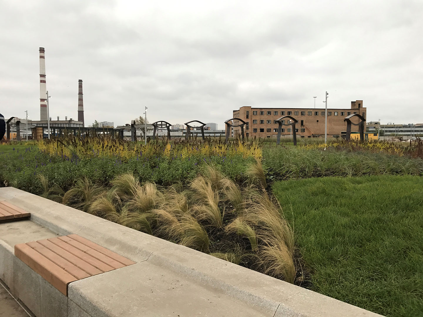 Cement bench overlooking grasses and building