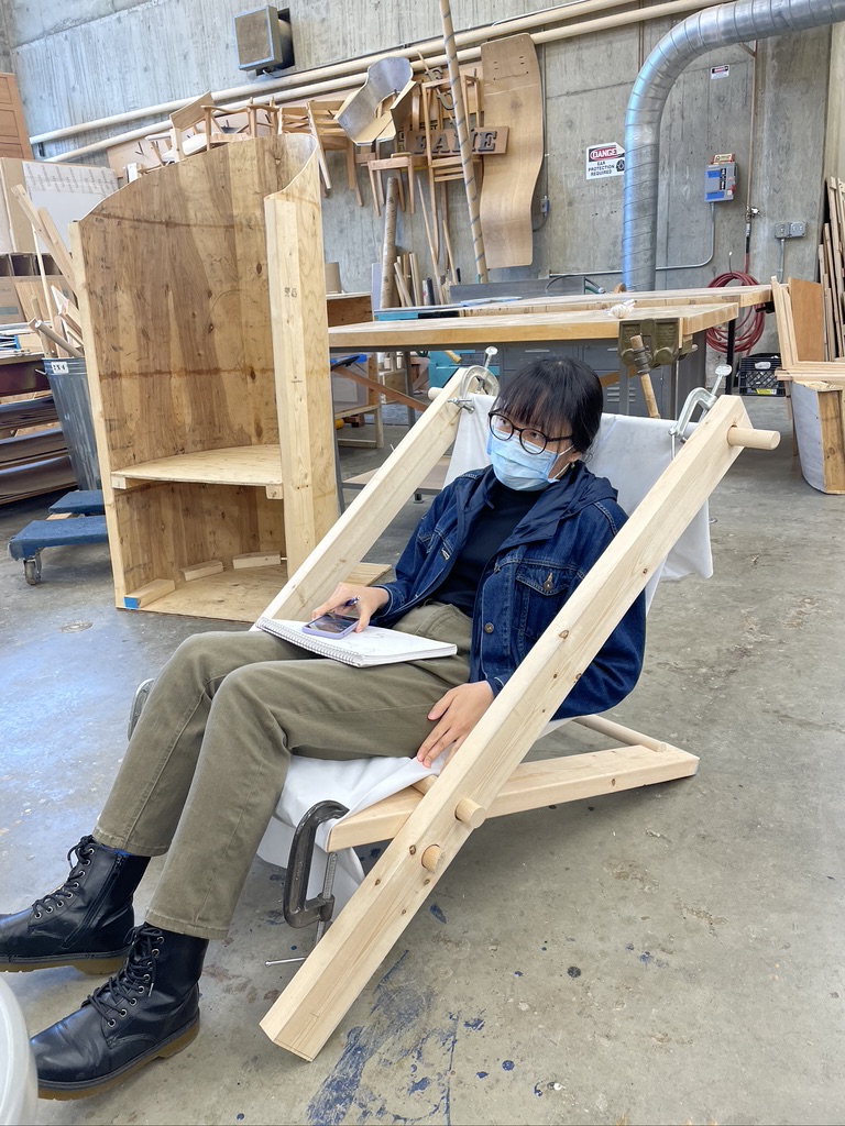 Person sitting a low to the ground wood chair