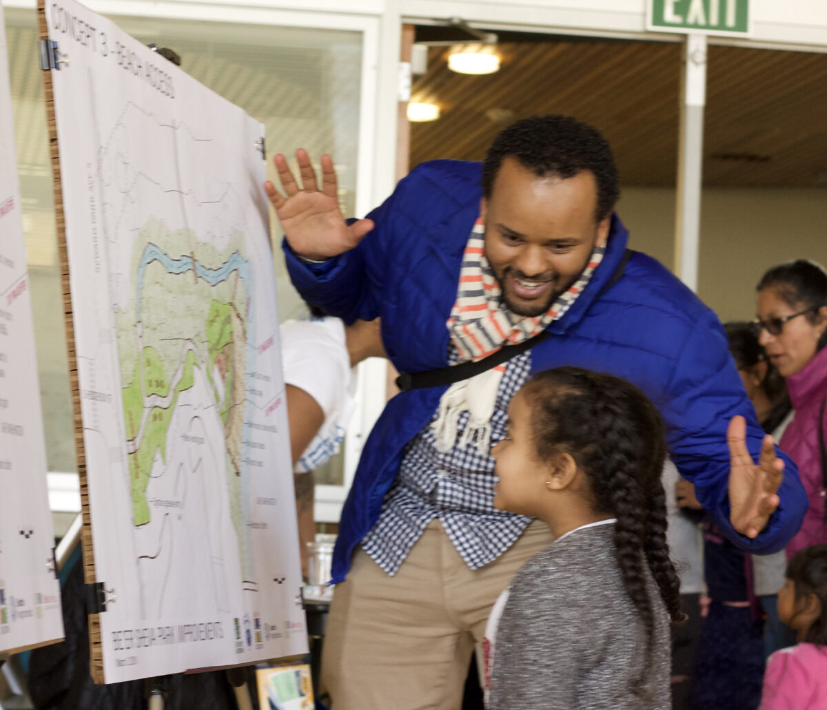 Biruk Belay engaging with a young community member at the Rainier Beach Beer Sheva Park project. 