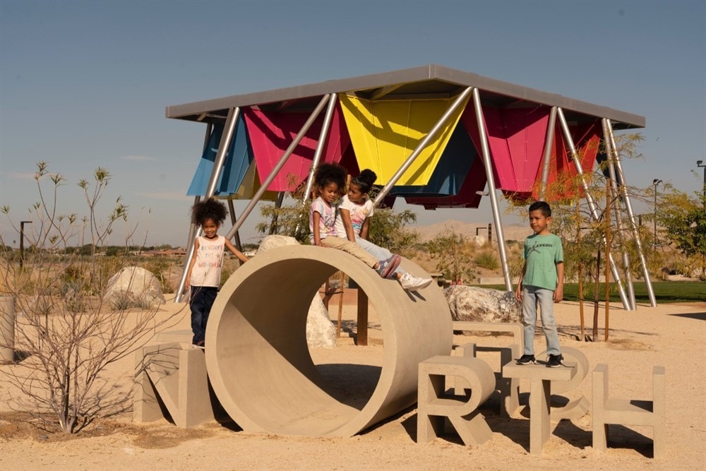 Children sit on sign that says North