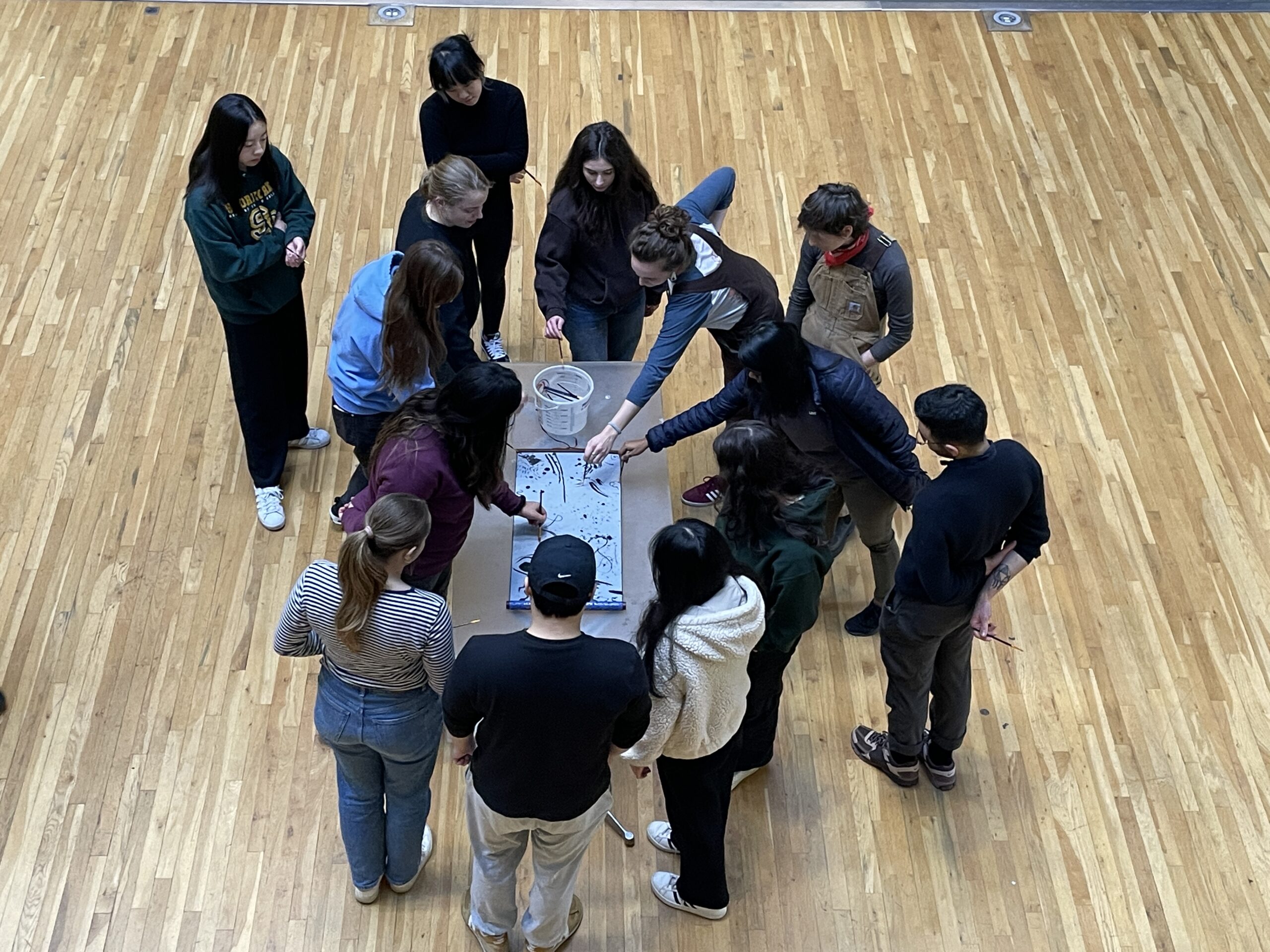 Group of people gather around a table pointing to drawings