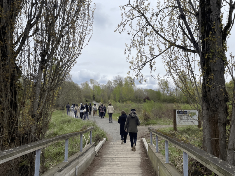 people walking down a path at Union Bay Natural Area, looks across bridge to see people walking