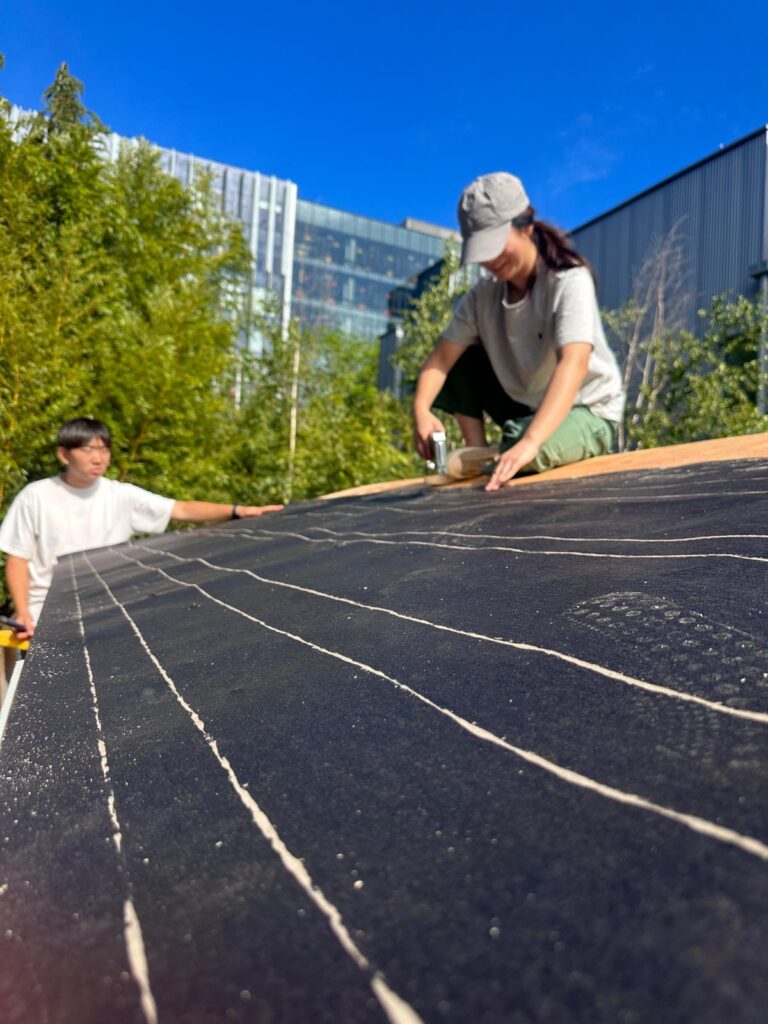 students work on roof of tiny house