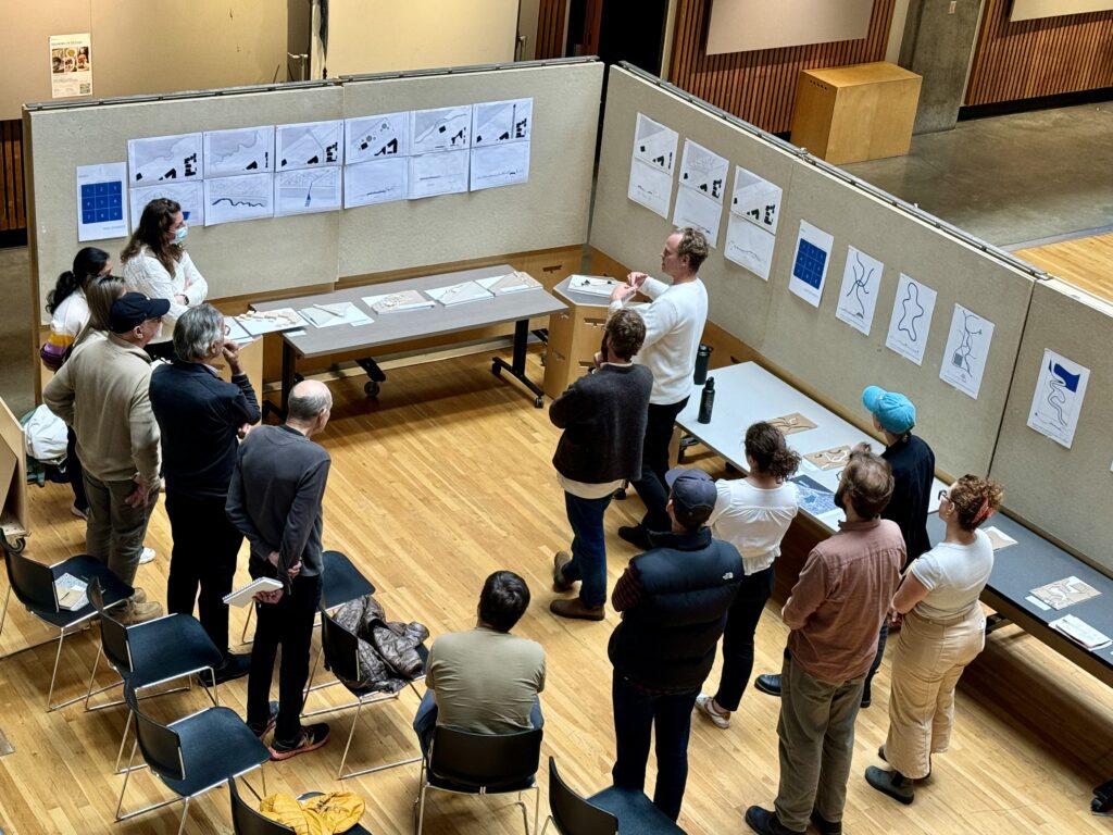 students standing in open room looking at posters on walls