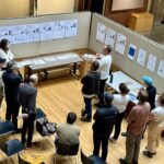 students standing in open room looking at posters on walls