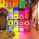 Brightly lit room with hanging shirts and rocks on the ground